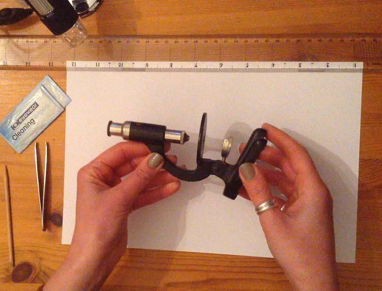 Hands holding toy microscope to inspect the parts