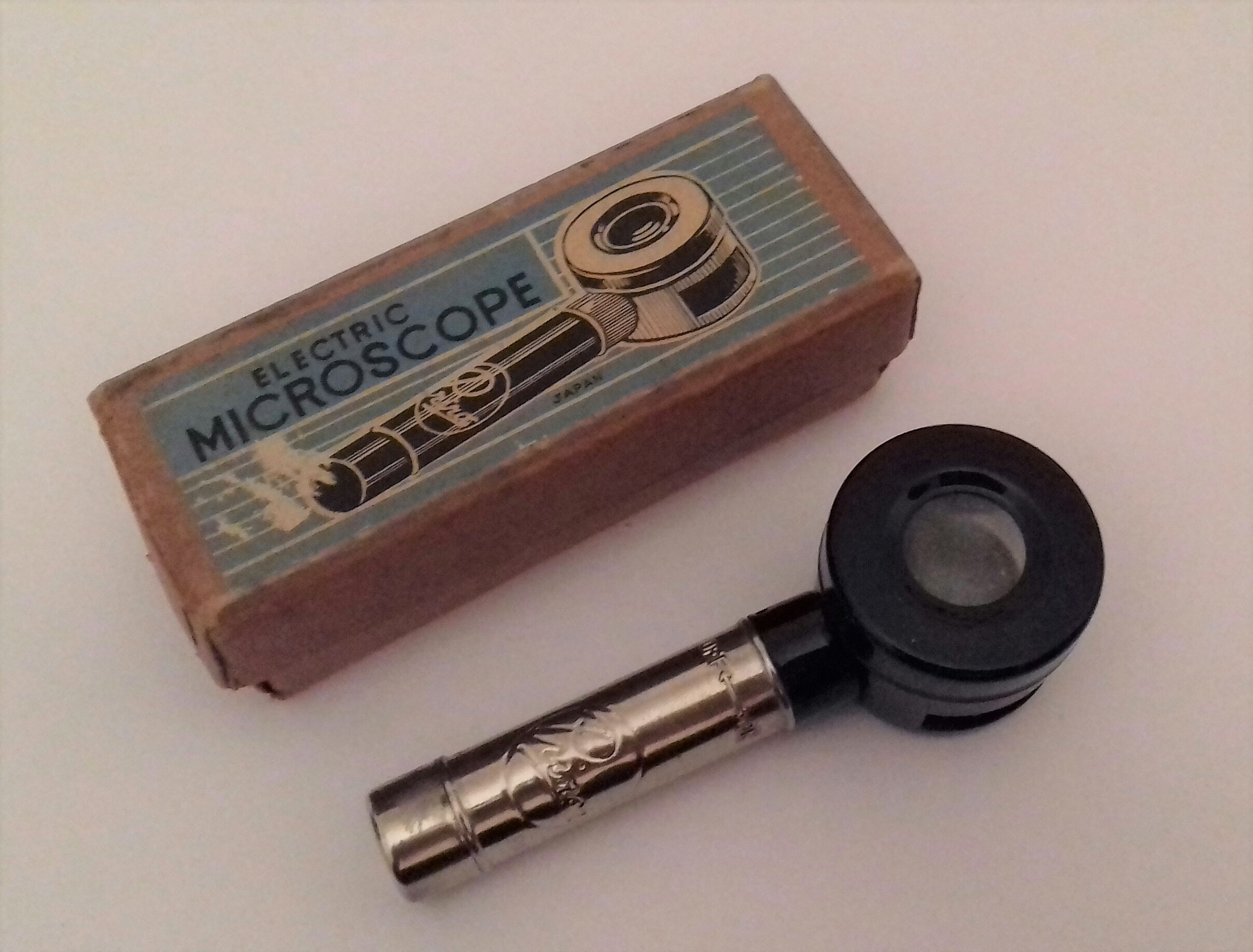 A toy microscope that is a small round lens on a handle